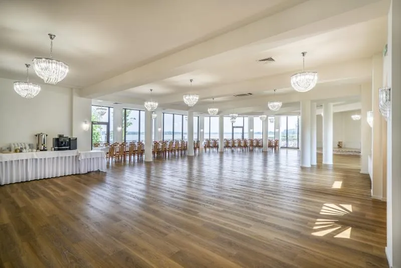Sala Złota od strony wejścia — bufet przy oknie, parkiet i rząd nakrytych stołów w głębi